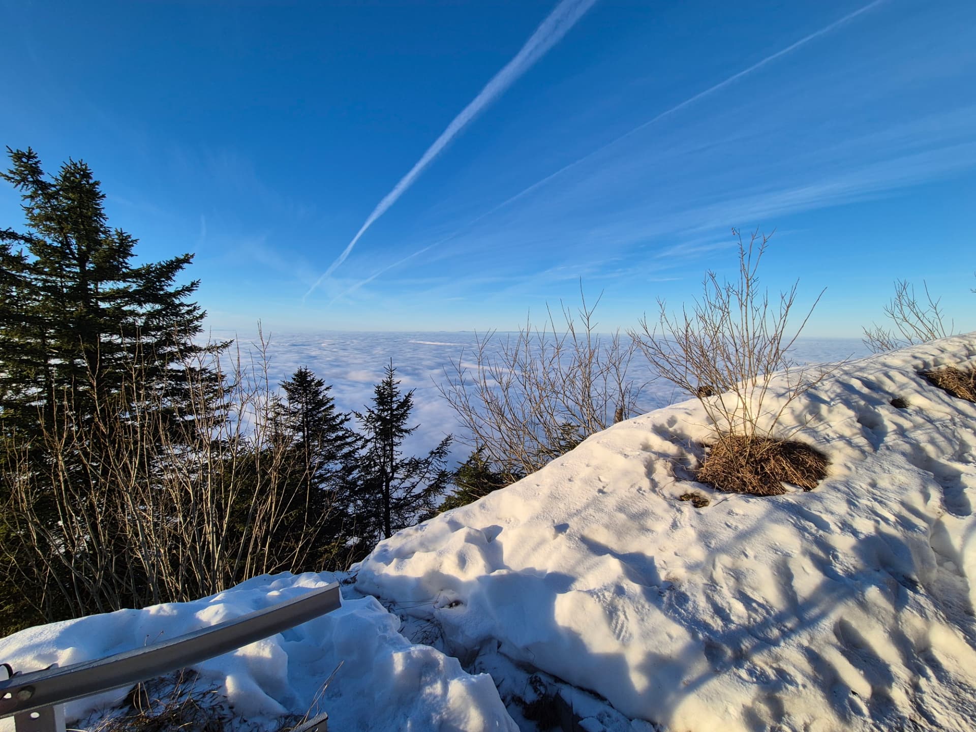 Weiter Blick über Schnee und eine geschlossene Wolkendecke in den Schweizer Alpen