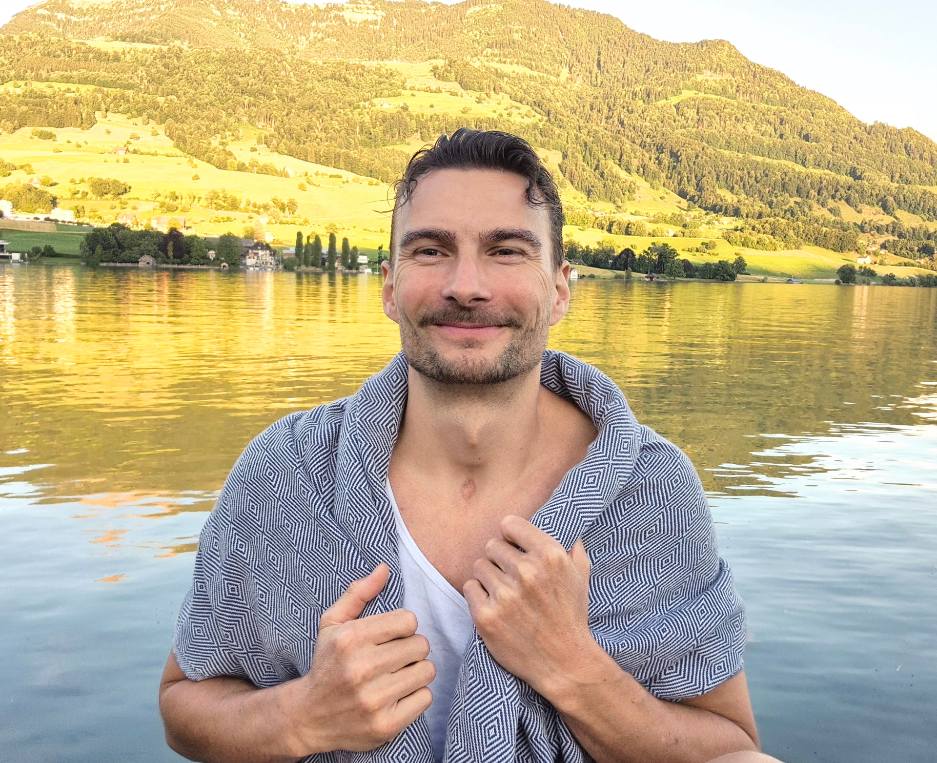 Felix Schulze am See vor Bergen im warmen Abendlicht